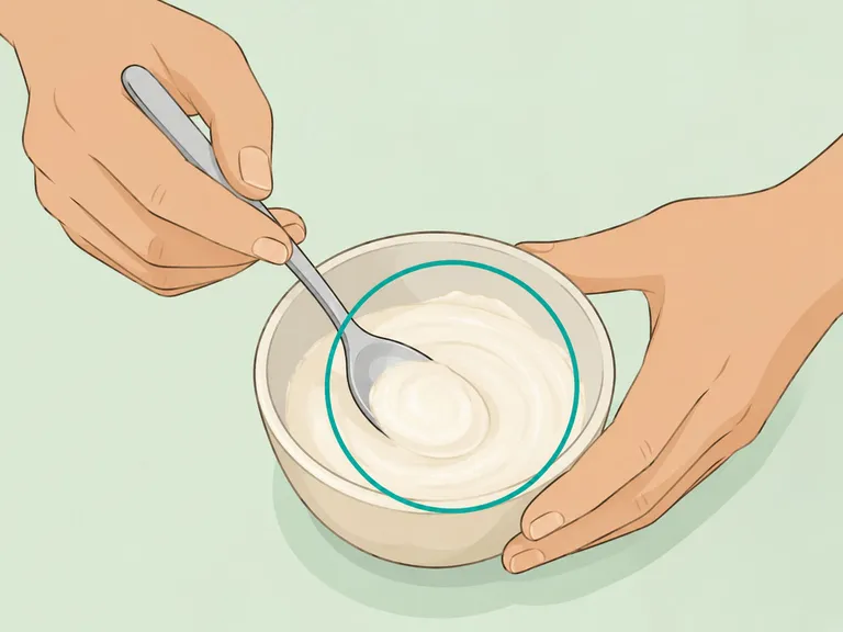 Hands mixing a loose smooth baking soda cream.
